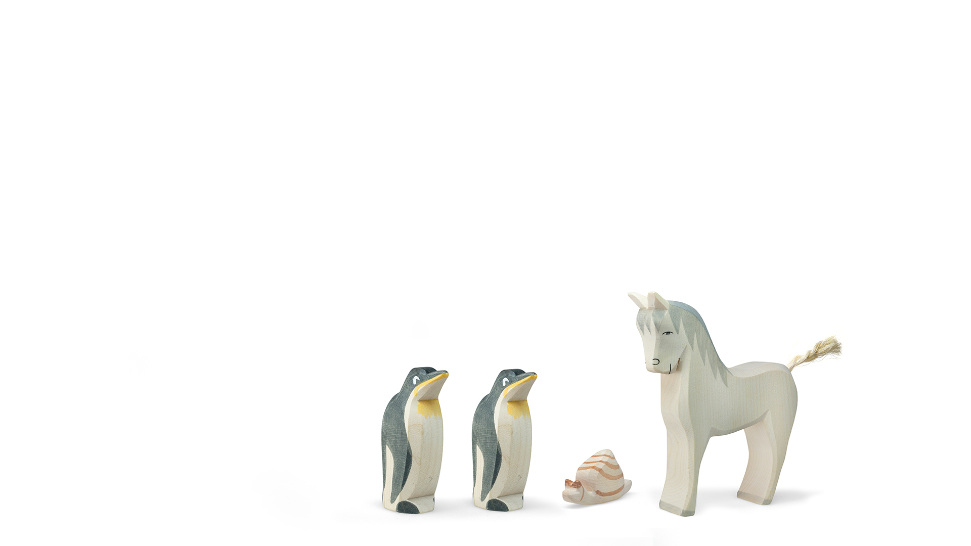 Wooden toy animals: three penguins, a horse, and a small snail on a white background.