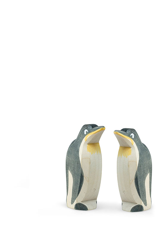 paarberatung-tablet Pair of wooden penguin figurines facing each other on a white background.